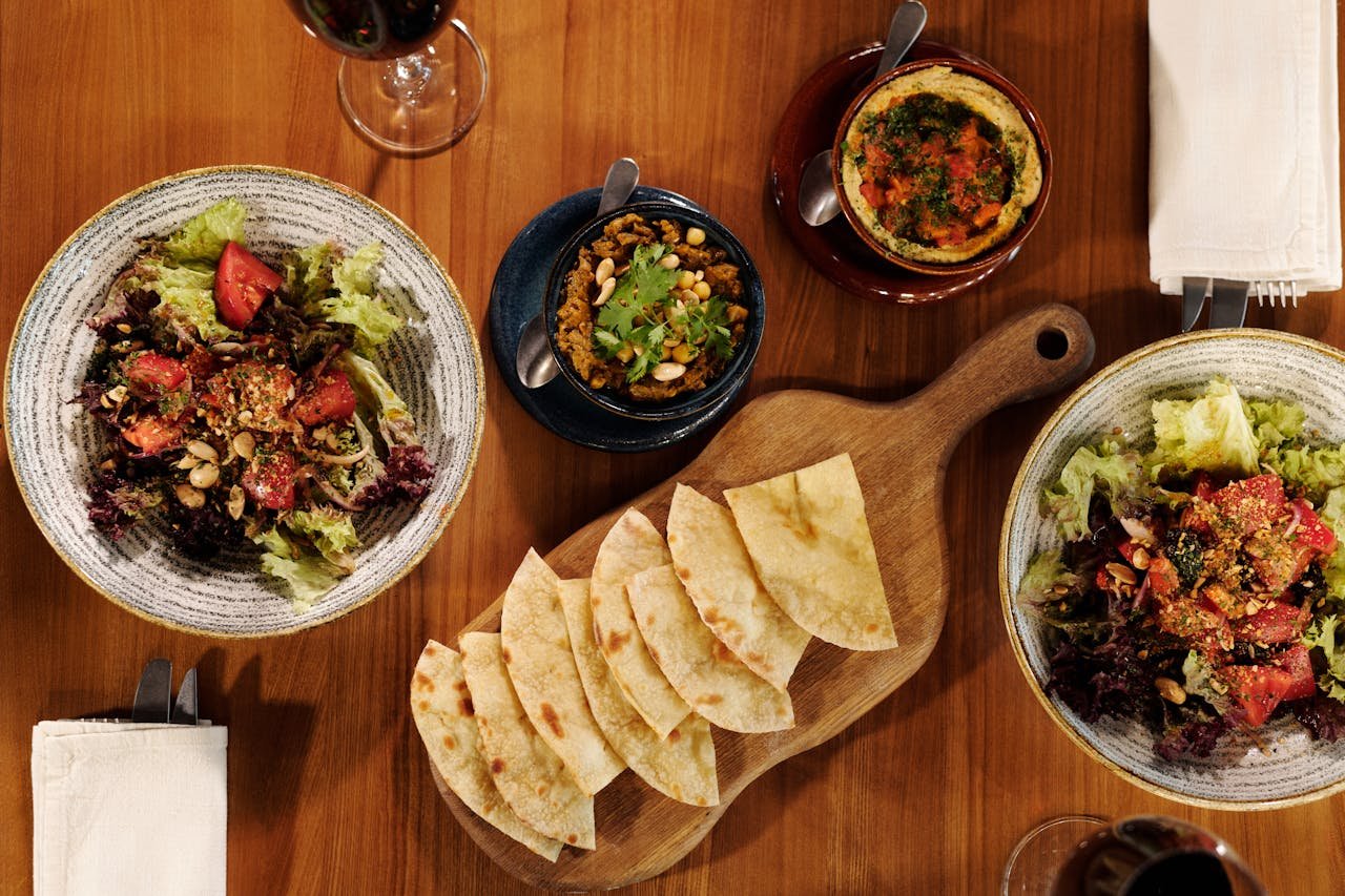 Enjoy a variety of Mediterranean dishes, including salads and hummus, shot from above.